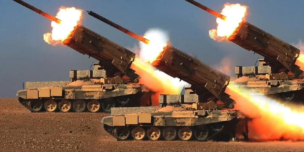 | Alground tre veicoli cingolati che lanciano simultaneamente grossi razzi nel deserto