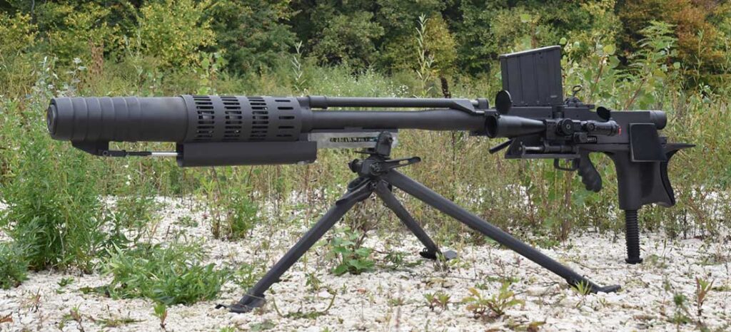 heavy machine gun mounted on a bipod and tripod in a sandy grassy field outdoors