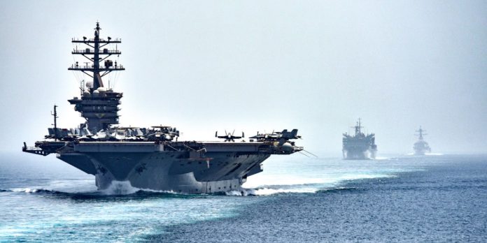 La portaerei americana USS Dwight D. Eisenhower attraversa lo Stretto di Hormuz seguita da una nave di supporto e da un cacciatorpediniere