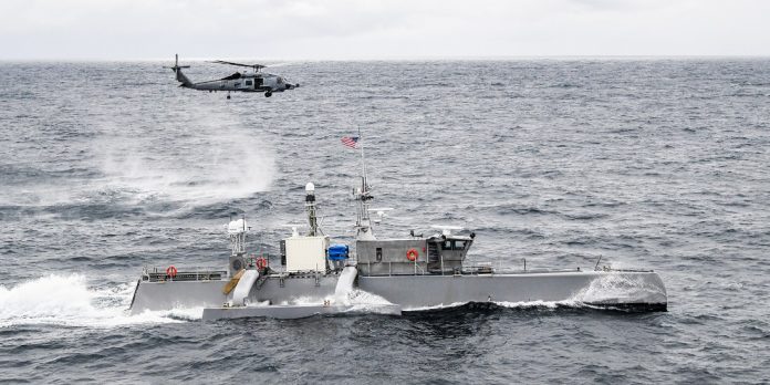 La nave senza equipaggio Seahawk in navigazione durante un'esercitazione della Marina statunitense, con un elicottero in volo