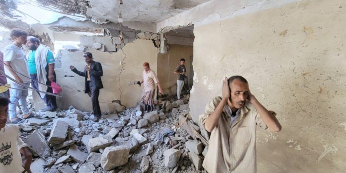 Abitanti tra le macerie di un'abitazione nel quartiere di Seina a Taiz, Yemen, dopo un colpo di missile